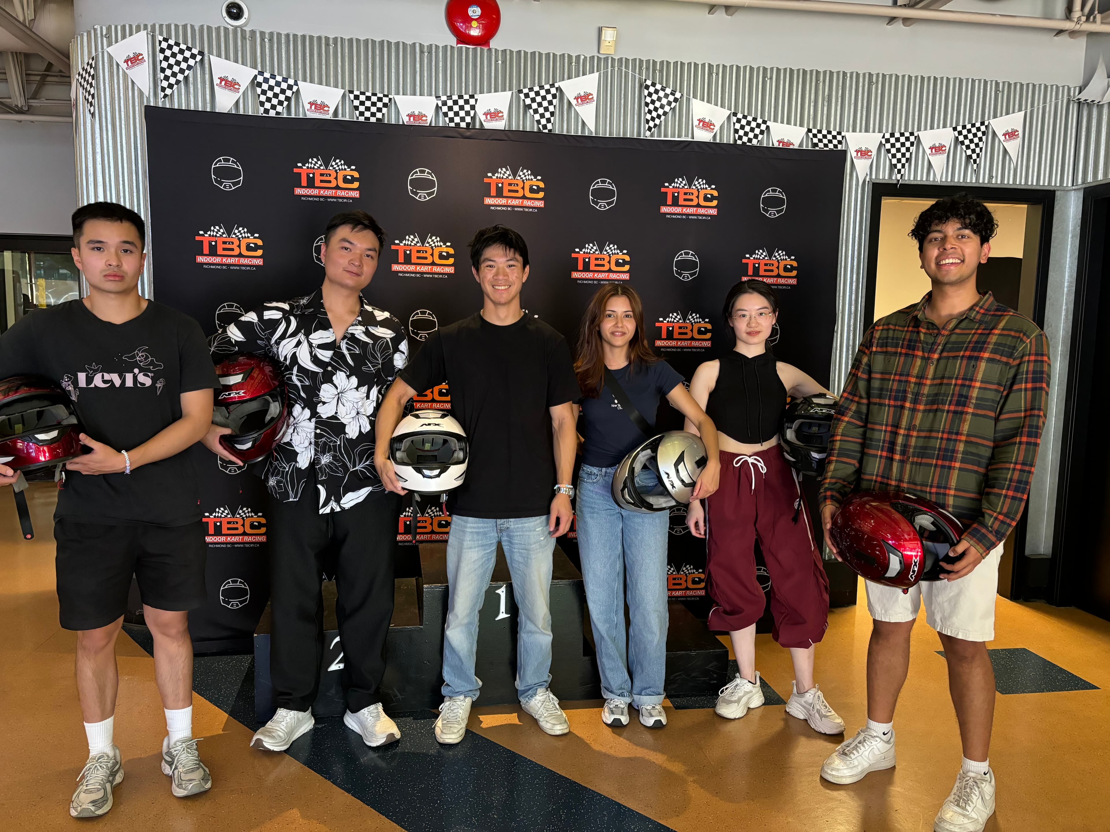 The six-person WorkInProgress team at an indoor kart-racing track